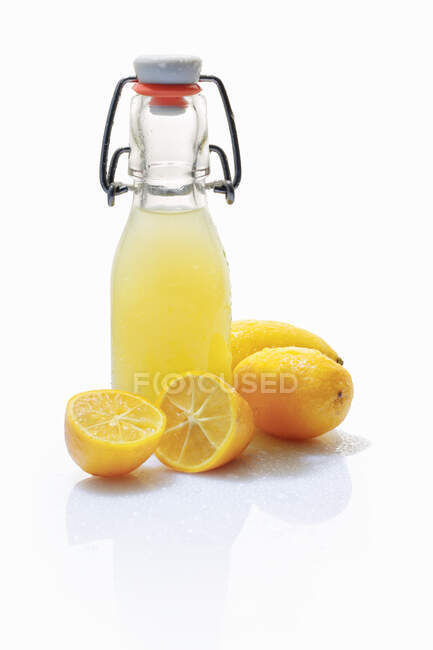 Limequat juice and fresh limequats — Stock Photo