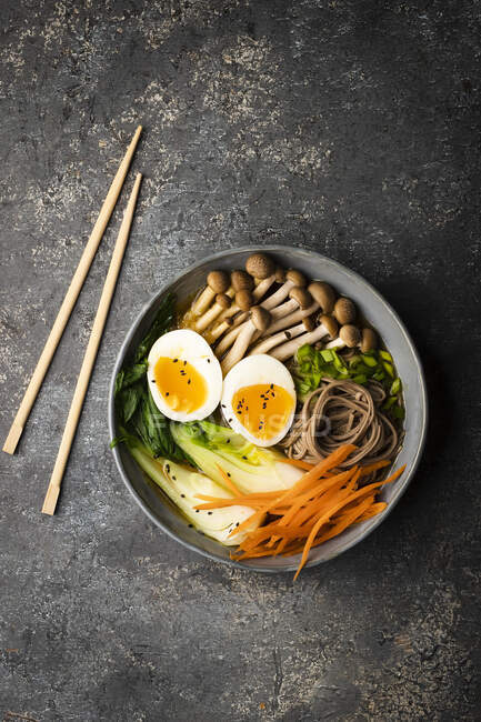 Miso soup with pak choy, carrot, soba pasta, mushrooms, egg and black sesame seeds — Stock Photo
