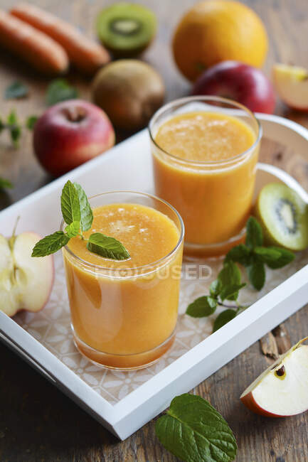 Dos vasos de jugo de frutas en una bandeja - foto de stock