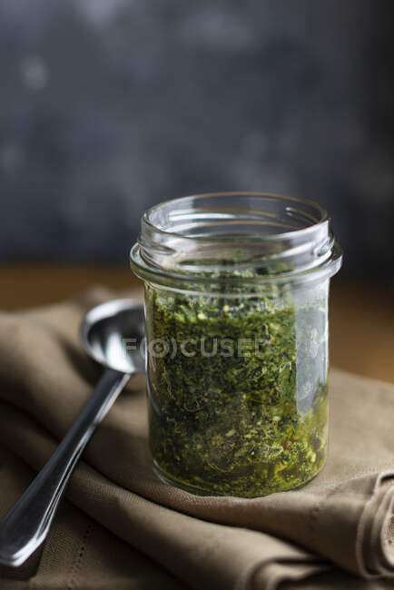 Pesto verde hecho con perejil, menta y nueces en un frasco - foto de stock
