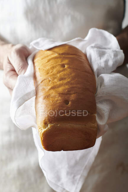 Cropped shot of person loaf of white bread — Stock Photo