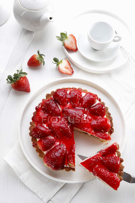 Tart with cheese and strawberries in jam and fresh strawberries on table — Stock Photo