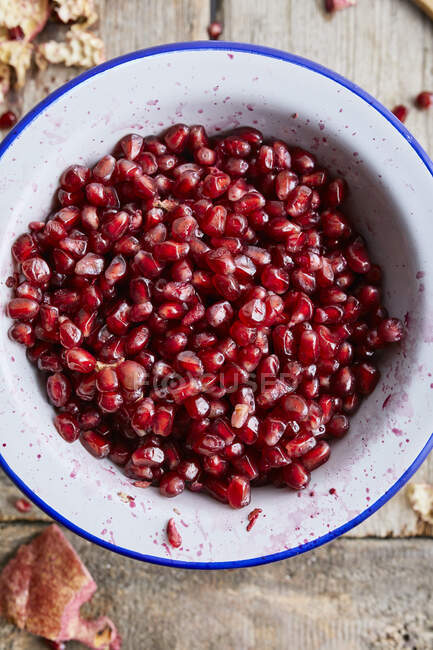Fresh peeled pomegranate in a white bowl — Stock Photo