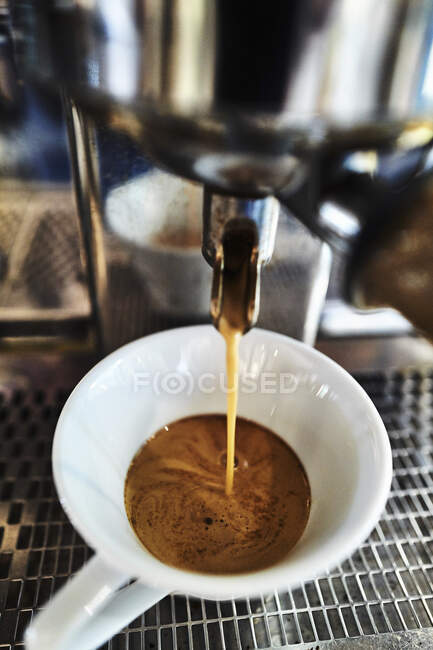 Kaffee fließt aus einer Espressomaschine — Stockfoto
