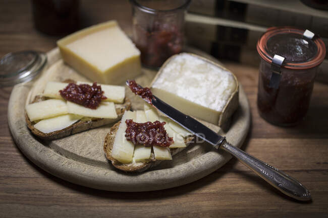 Pain au fromage avec moutarde à la figue sur planche de bois — Photo de stock
