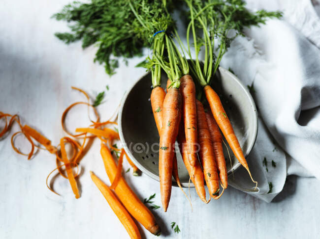 Zanahorias peladas y colador - foto de stock