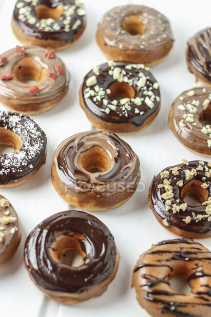 Varios donuts con glaseado de chocolate - foto de stock