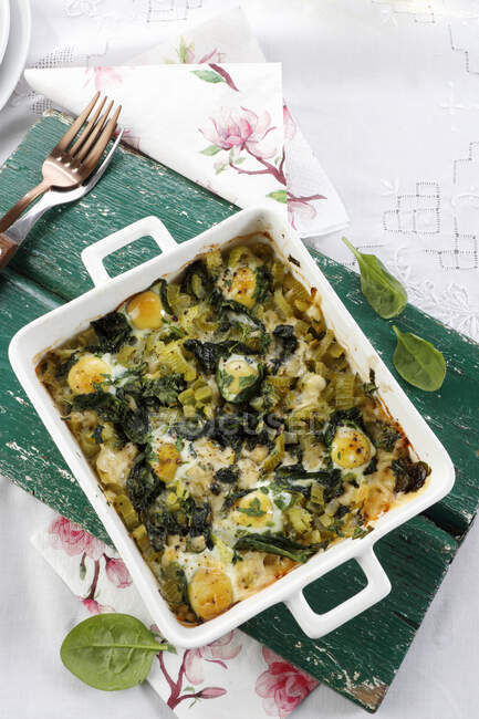 Quail eggs baked with leek and spinach in tin — Stock Photo