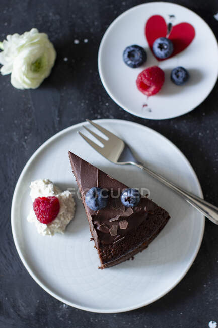 A slice of chocolate cake with ganache and fresh berries — Stock Photo