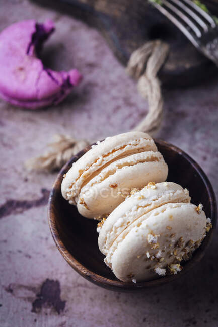 Vanilla macarons with crumbs in bowl, close up shot — Stock Photo
