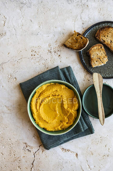 Bowl of hummus with mashed potatoes and croutons on a white wooden background. selective focus. - foto de stock