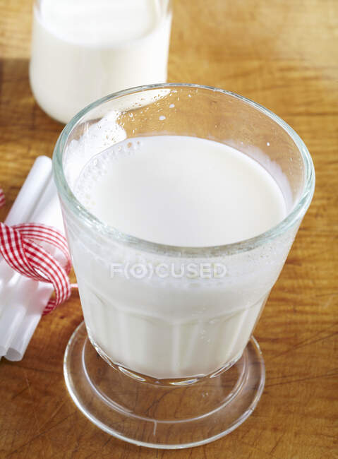 Glass of cold, fresh milk on wooden surface — Stock Photo