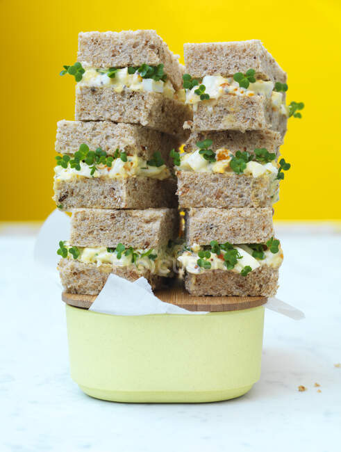 Huevos, hierbas y sándwiches de mayonesa apilados en recipiente - foto de stock
