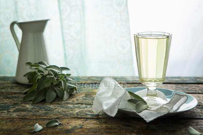Шавлієвий сироп у склянці та листі шавлії на столі — стокове фото