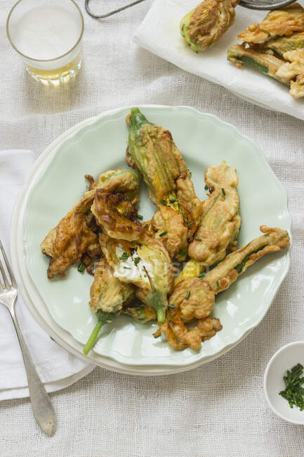 Zucchini flowers filled with ricotta, fried in a beer dough, fresh chives — Stock Photo
