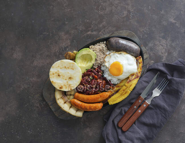 Bandeja paisa Pancia di maiale fritta colombiana, budino nero, salsiccia, arepa, fagioli, piantaggine fritta, uovo di avocado e riso — Foto stock