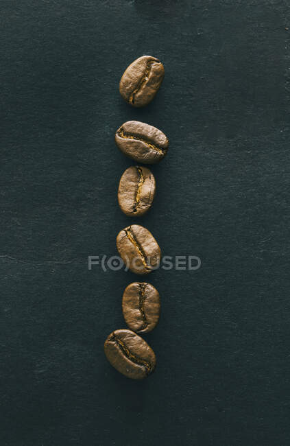 Une rangée de grains de café — Photo de stock