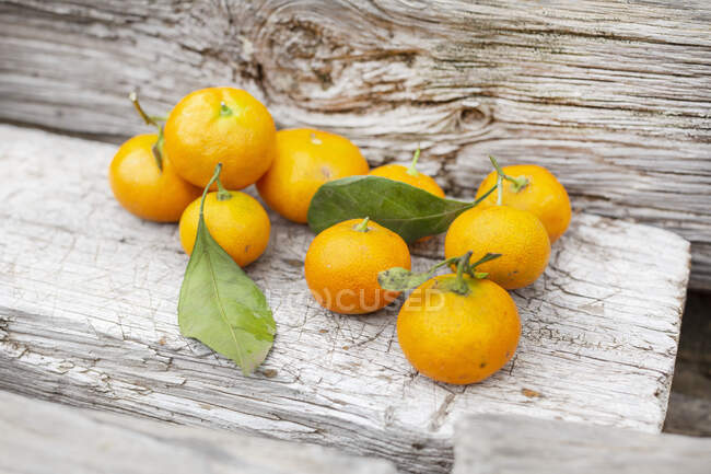 Mandarines fraîchement cueillies sur un fond en bois — Photo de stock
