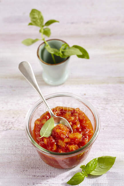 Pineapple and tomato chutney in jar with fresh basil - foto de stock