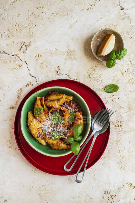 Миска раковин макарон с томатным соусом, песто и тертым пармезаном — стоковое фото
