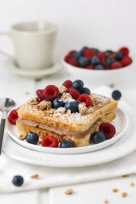 French toast with cream, berries, nuts and crumbs on plate — Stock Photo