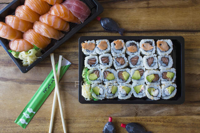 Sushi com pauzinhos e molho de soja para tirar — Fotografia de Stock