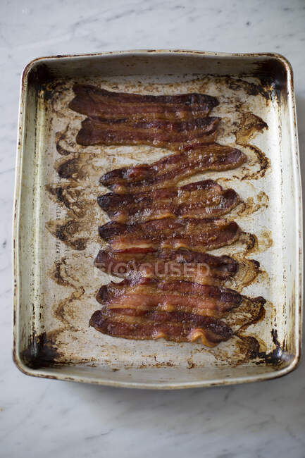 Fatias de bacon assado em estanho de metal — Fotografia de Stock