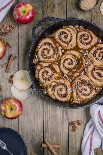 Apple pecan sticky buns with caramel sauce in a cast iron pan — Stock Photo