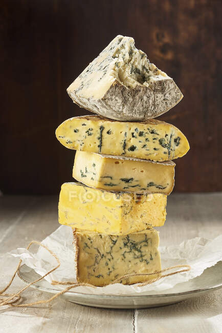 Selection of blue cheeses stacked up on paper — Stock Photo
