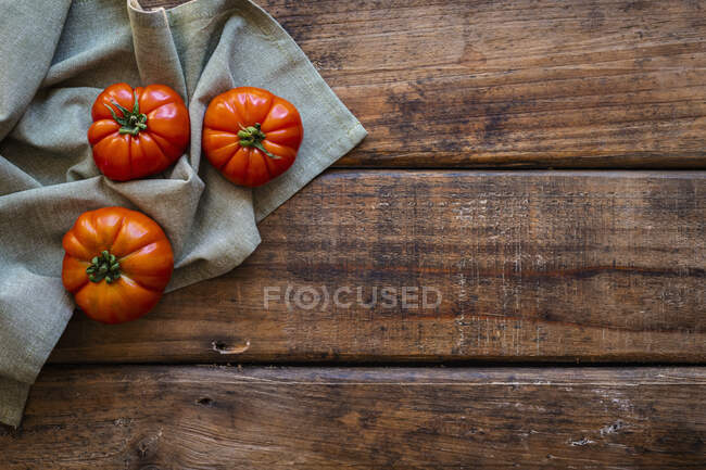 Tomates fraîches mûres sur fond de bois — Photo de stock