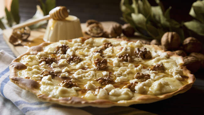 Sweet pizza with walnuts, goat cheese and honey — Stock Photo