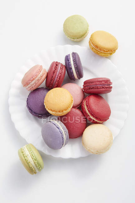 Colorful macarons on plate, top view — Stock Photo