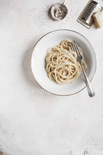 Cacio e pepe - Pasta de Bucatini con mantequilla, pimienta negra y pecorino - foto de stock