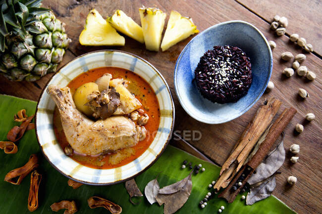 Curry de massaman de poulet thaïlandais servi sur riz au jasmin moelleux et noir — Photo de stock