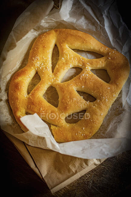 Pan de Fougasse recién cocido sobre papel de hornear - foto de stock
