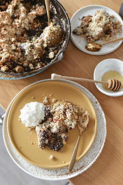 Baked fruit under crumble with whipped cream — Stock Photo