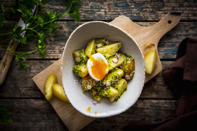 Potatoes served with herb pesto, onion and egg — Stock Photo
