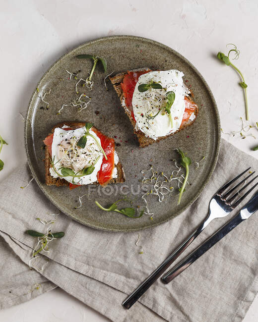 Bruschettas with cream cheese, salmon and poached eggs — Stock Photo