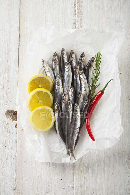Roher Fisch mit Zitrone und Rosmarin auf Holzgrund — Stockfoto