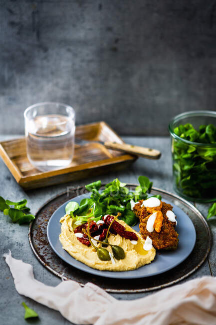 Falafel con hummus, foglie di lattuga, pomodori secchi e capperi — Foto stock