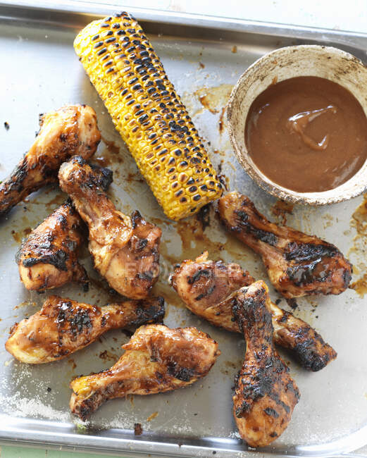 Grilled chicken legs with corn cob and barbecue sauce — Photo de stock