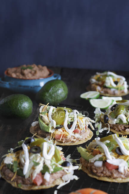 Chicken tostadas with jalapeno peppers, black olives, sour cream, lettuce, shredded chicken and fresh cilantro — Stock Photo