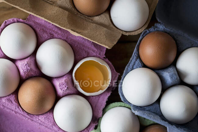 Uova bianche e marroni in scatole di carta, una spaccata — Foto stock