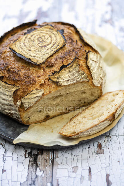 Кислий хліб зі скибочками на сільській поверхні — стокове фото