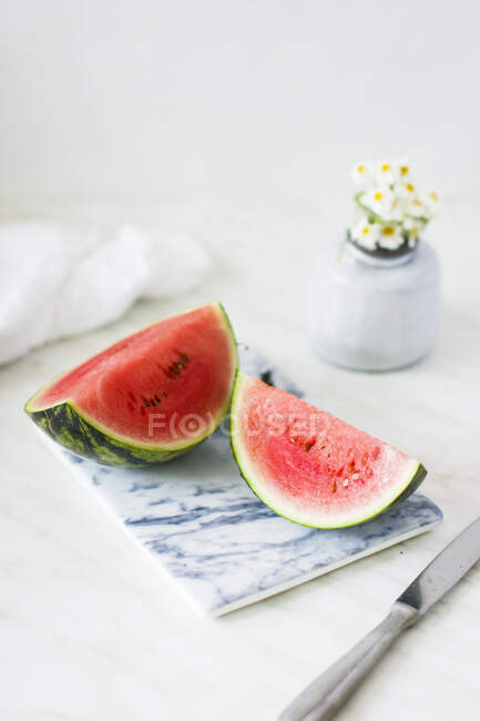 Watermelon wedges on marble chopping board — Stock Photo