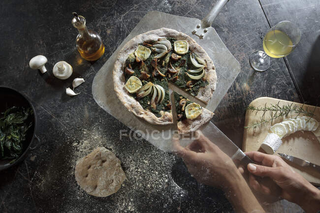 Pizza de harina de espelta con pesto de espinacas, ajo, cebolla, champiñones, romero y queso de cabra - foto de stock