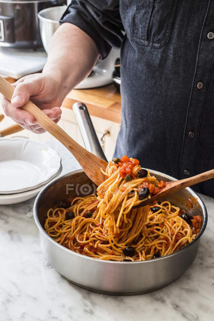 Man with pasta puttanesca — Stock Photo