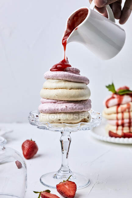 Hand legt flüssige Marmelade aus Krug auf Erdbeerpavlova — Stockfoto