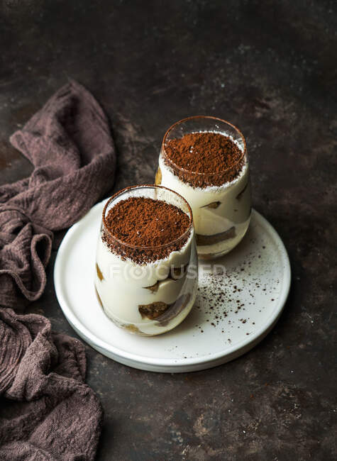 Десерты со вкусом кофе тирамису подаются в стаканах на тарелке — стоковое фото
