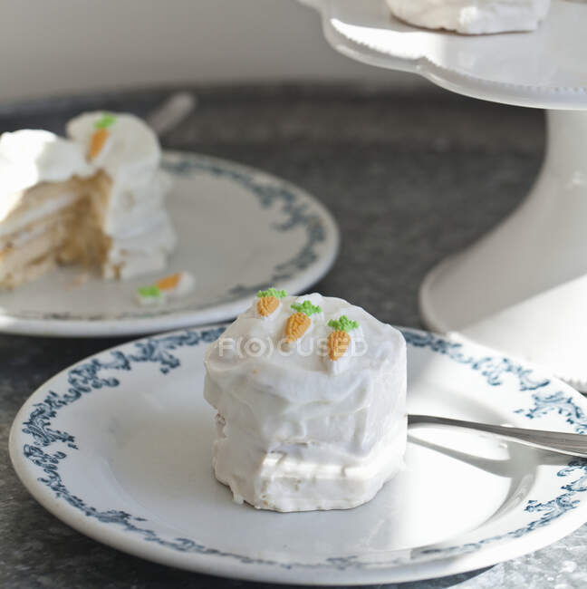 Mini tortas de vainilla para Pascua decoradas con glaseado batido y mini zanahoria - foto de stock